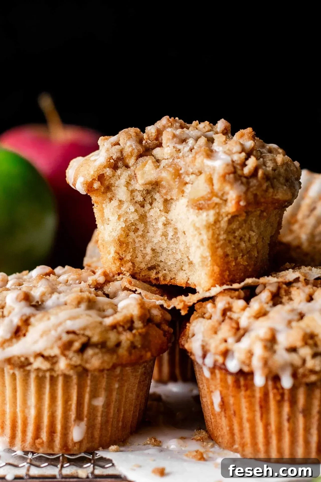 apple crumb muffins on wire rack with bite missing from one