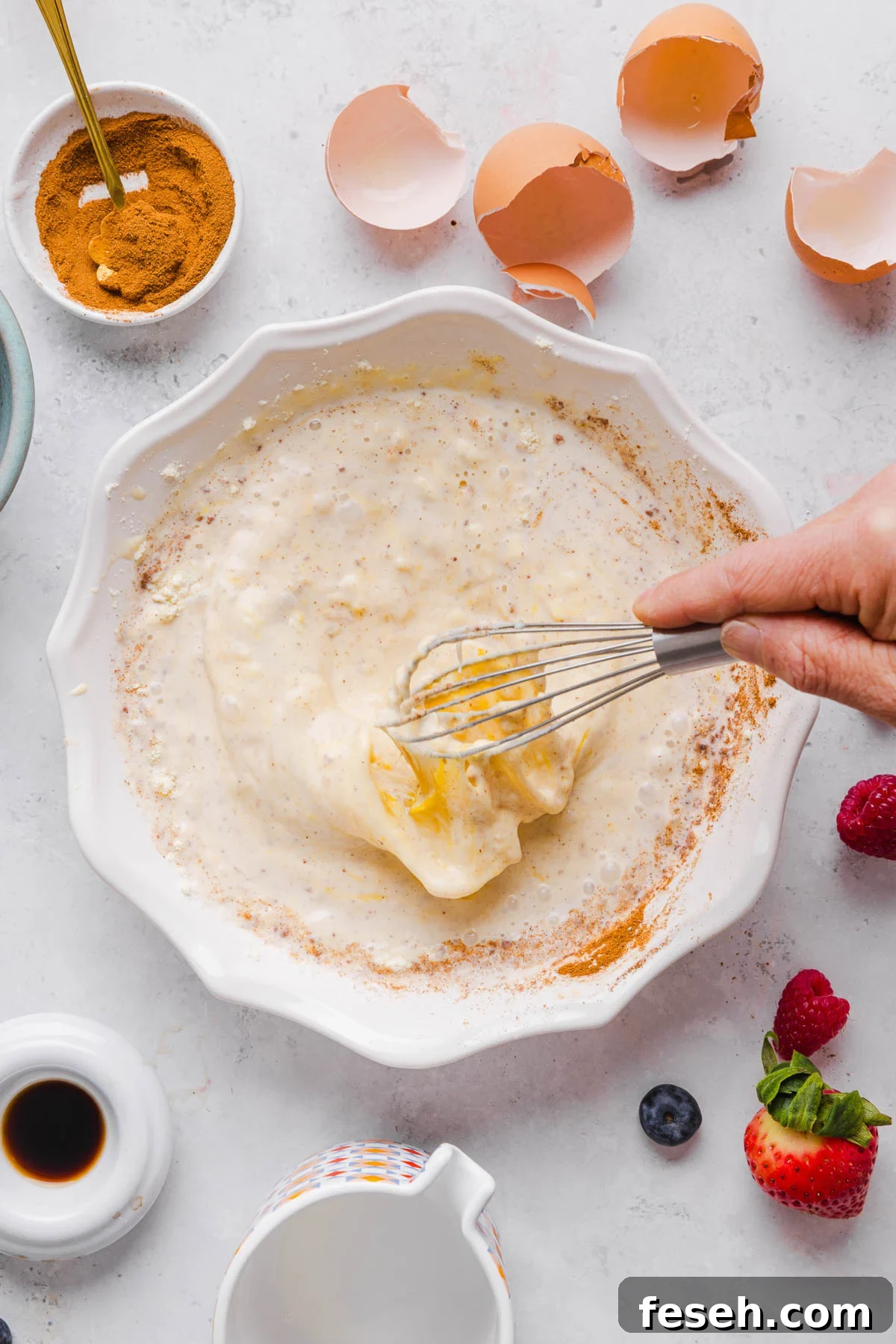 Whisking together the batter for the french toast in a shallow baking dish.