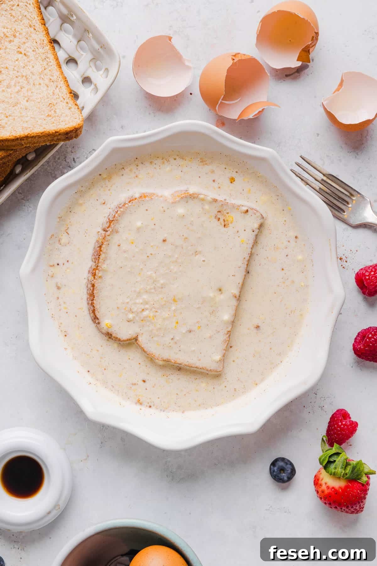 A piece of whole wheat bread dredged in the shallow baking dish with the french toast batter.