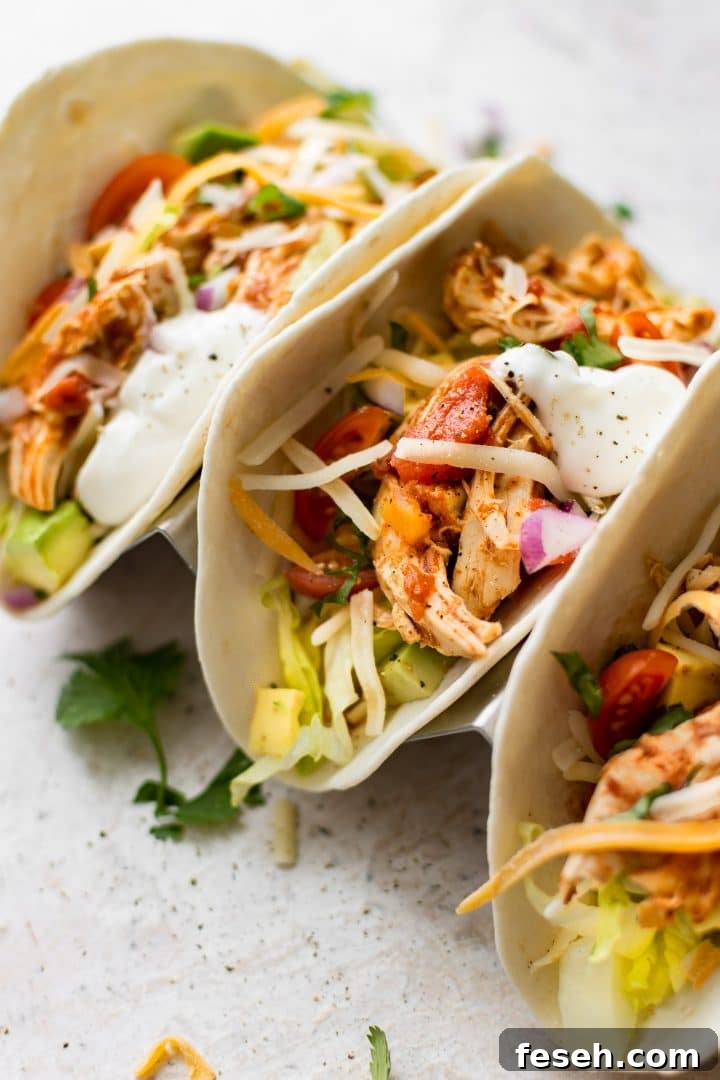 close-up of three Instant Pot shredded chicken tacos with homemade salsa