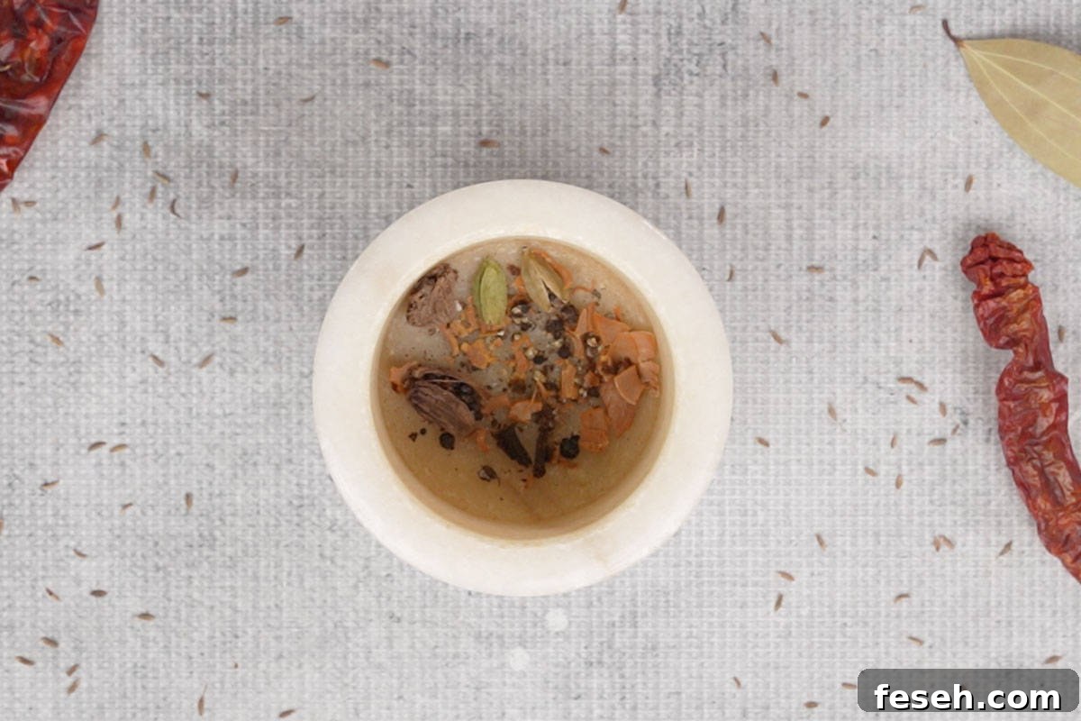 Crushed whole spices in a mortar and pestle.