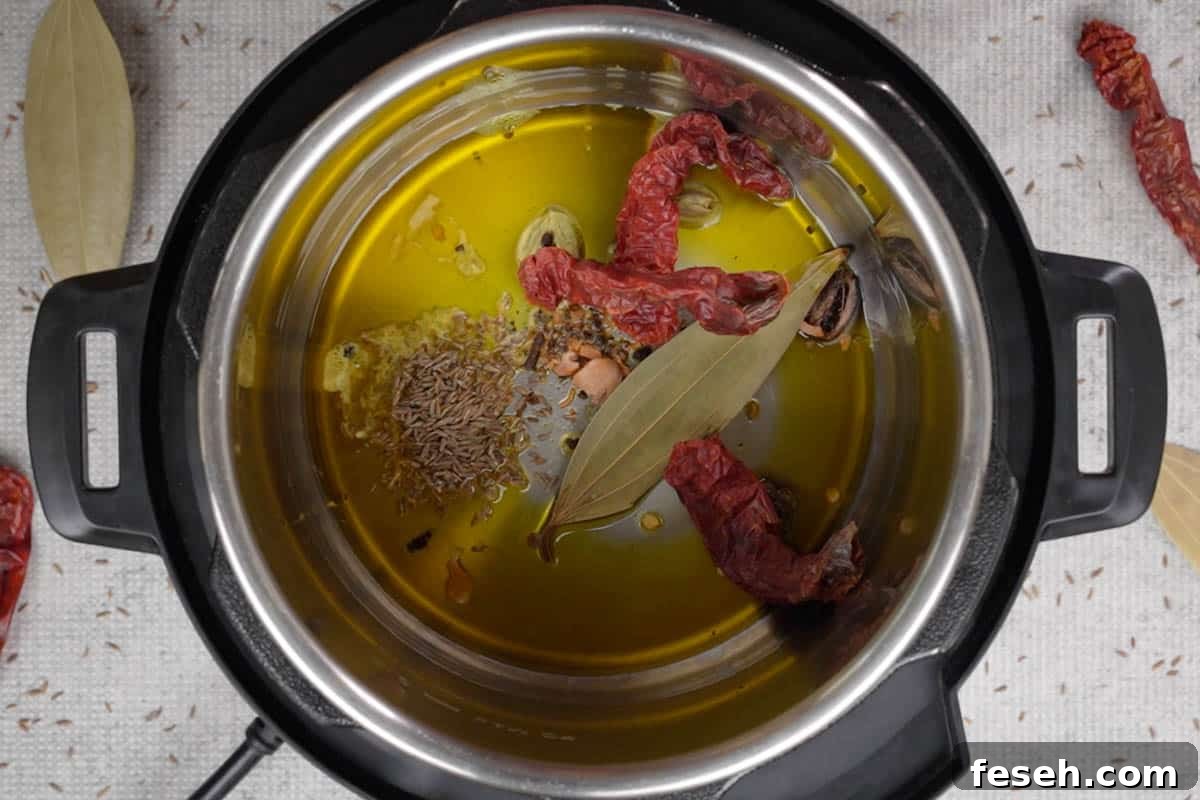 Crushed whole spices, bay leaves, dry chilies and cumin seeds added to hot oil in instant pot.