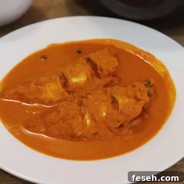 goan fish curry with coconut served in a white bowl.