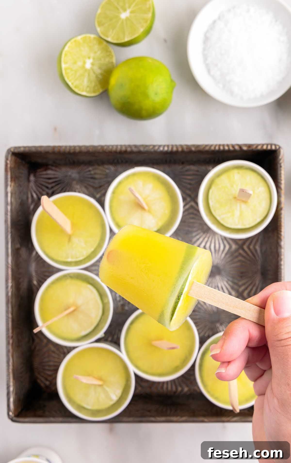 close up shot of Margarita Popsicles with slices of lime in a baking dish