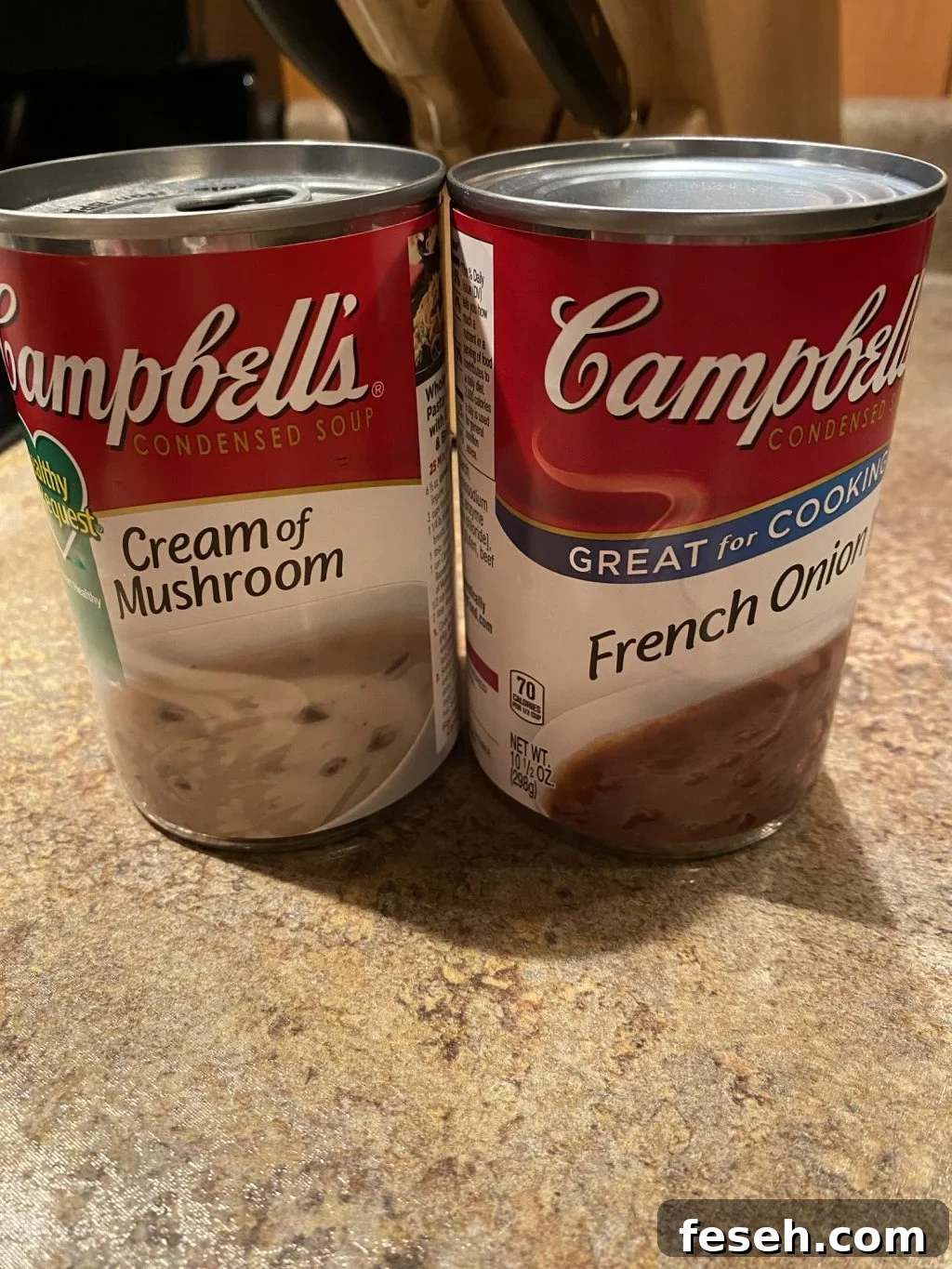 A can of Campbell's Cream of Mushroom soup next to a can of Campbell's French Onion Soup