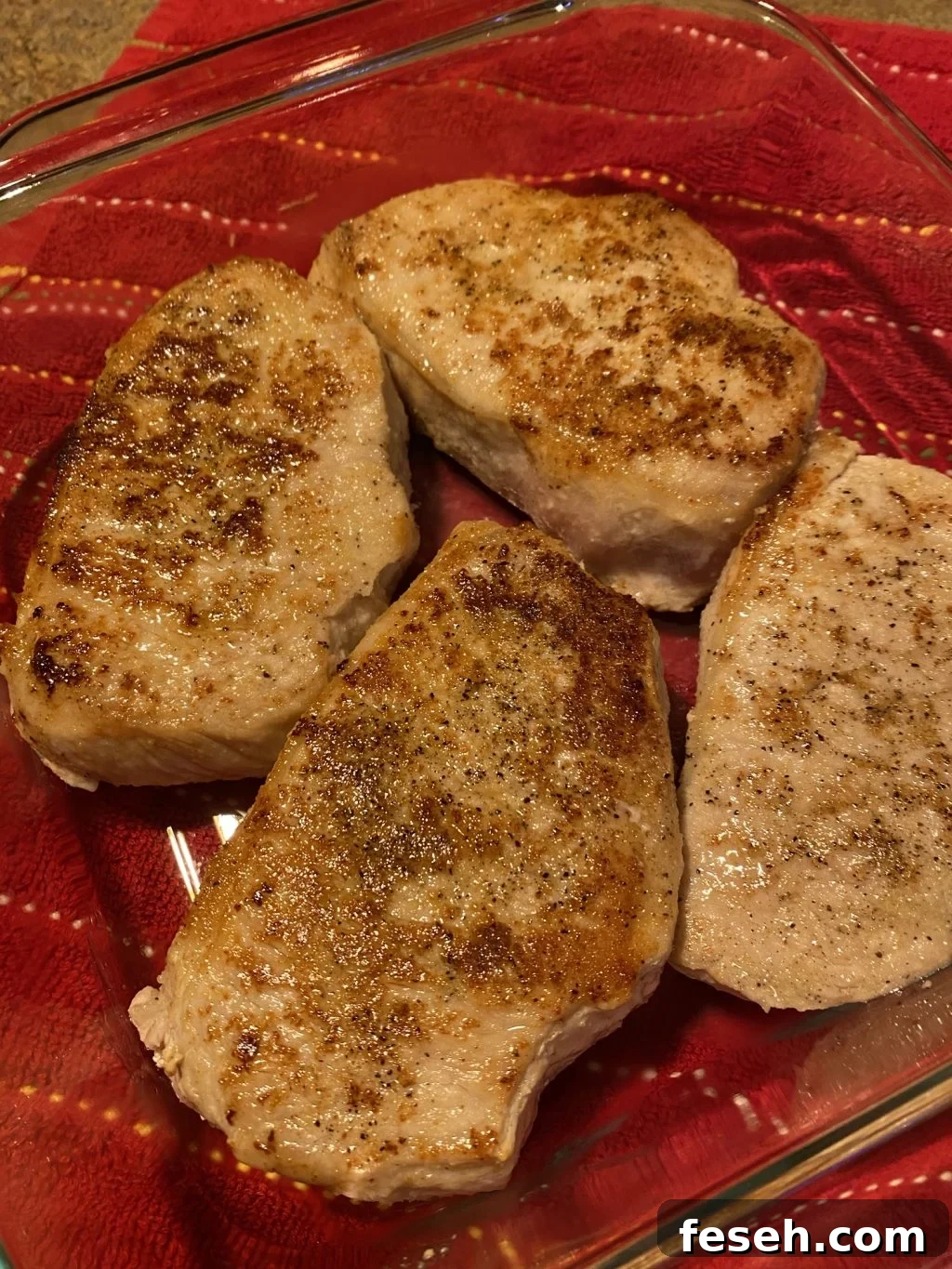 Cooked and seasoned pork chops in a glass baking dish