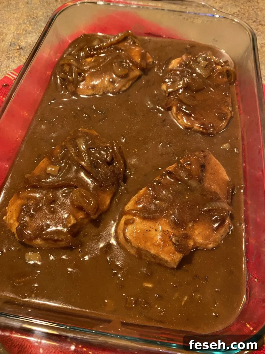 Four pork chops covered in gravy