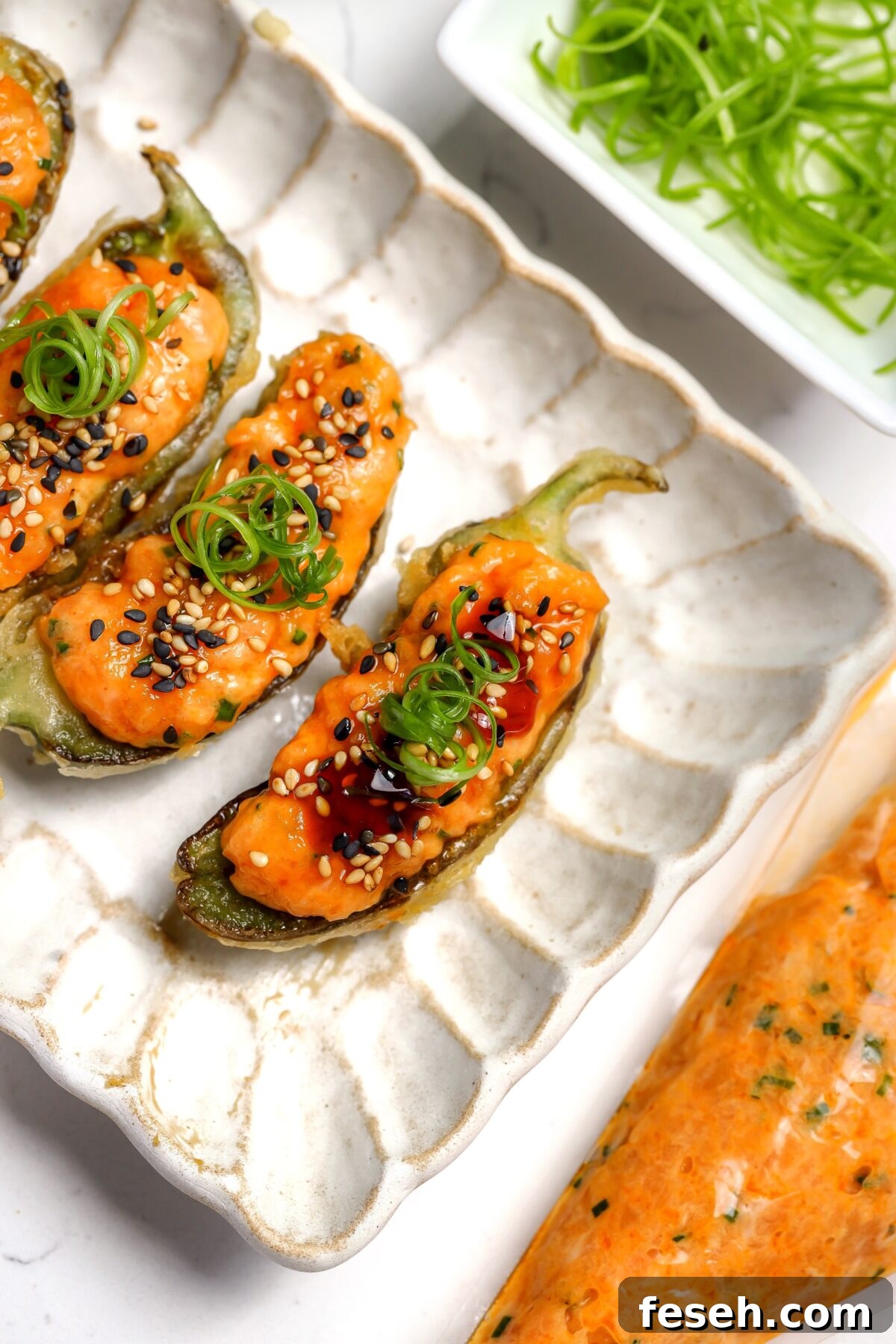 A tempura coated jalapéno with spicy salmon and eel sauce inside.