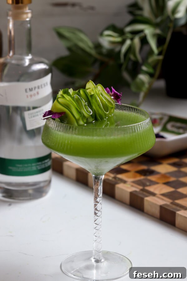 Cucumber martini made gin but you can make it with vodka, garnished with edible flowers and sliced cucumber.