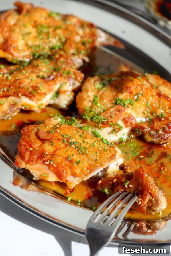 Crispy chicken thighs seared in a skillet and covered in a sake butter sauce.