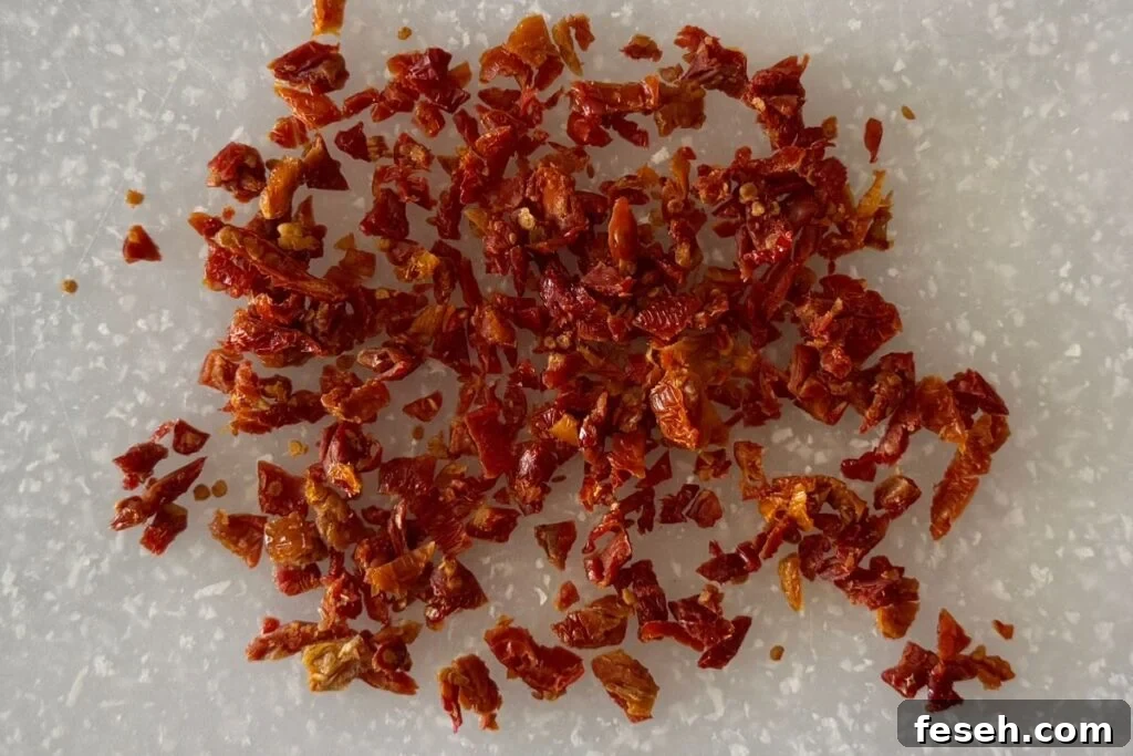 Chopped sun-dried tomatoes on a cutting board.