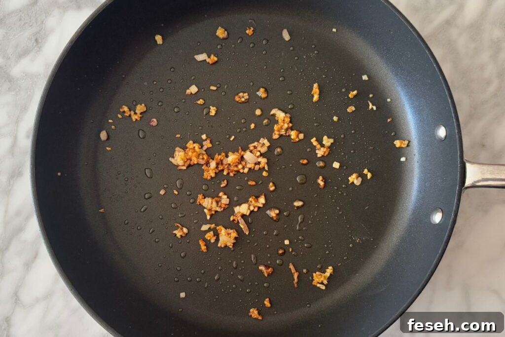 Cooked shallots and garlic in a skillet.
