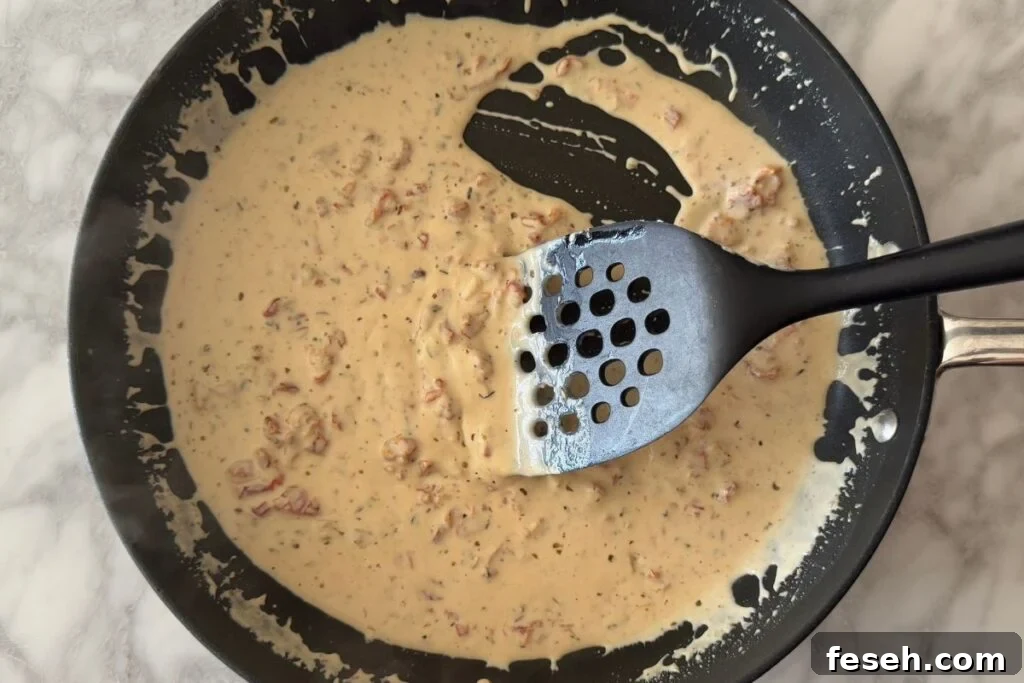 Mixed sauce for Marry Me Chicken Pasta in skillet.