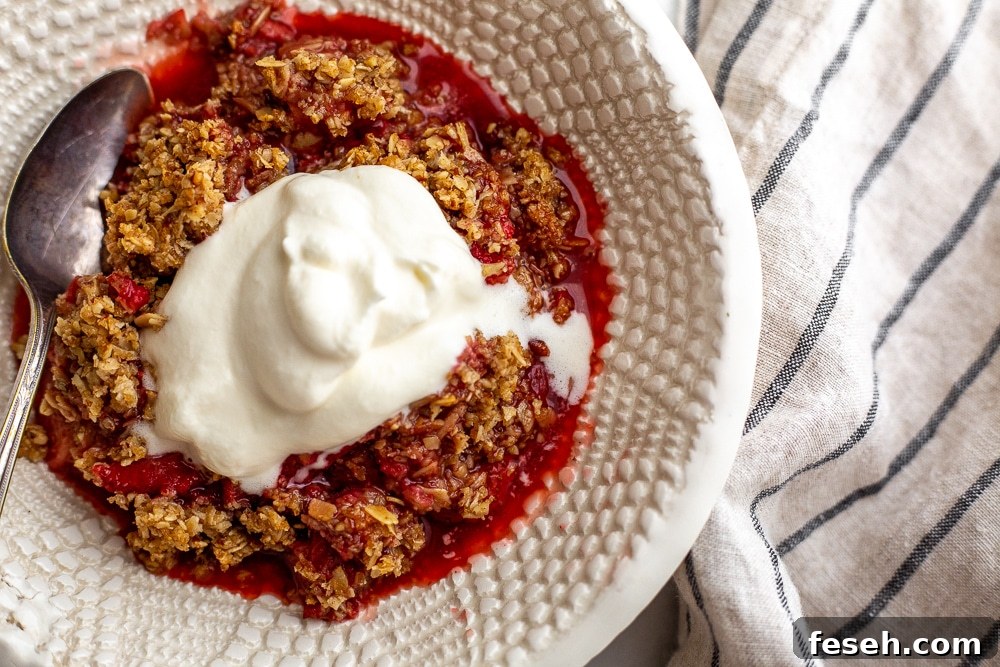 Close-up of gluten free strawberry crisp in bowl with whipped cream on top