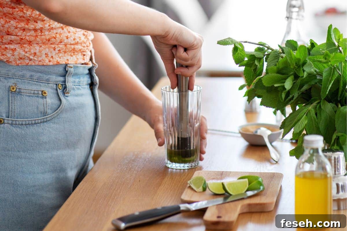 Muddling limes in a cocktail.