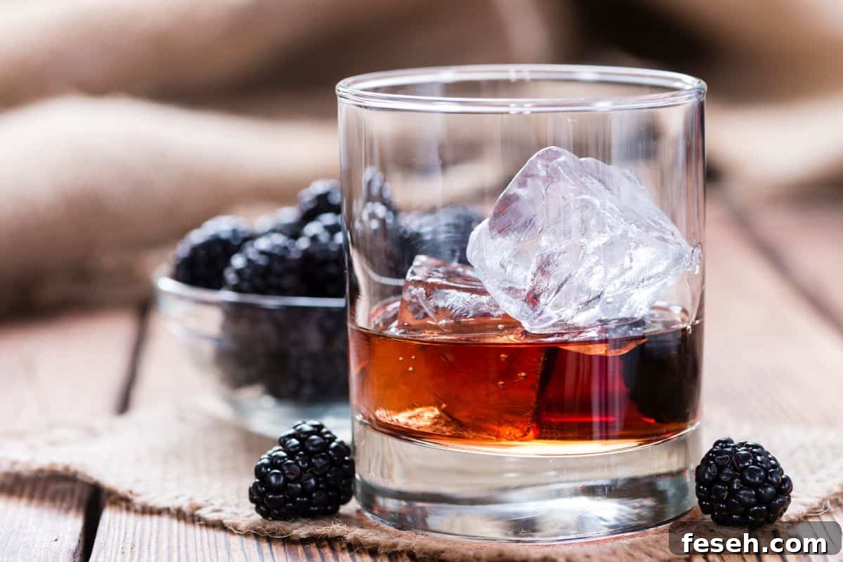 Blackberries and whiskey bourbon in a lowball glass.