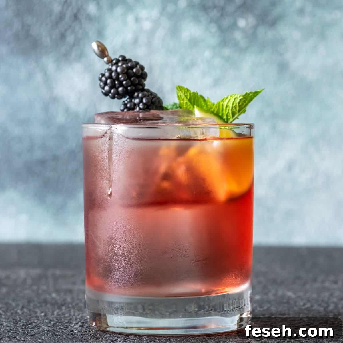 Blackberry whiskey smash with berries and mint leaf.
