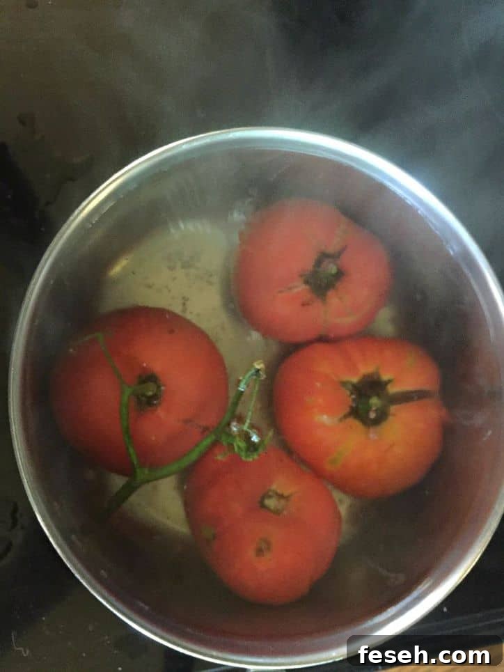 Four whole tomatoes in boiling water in stock pot