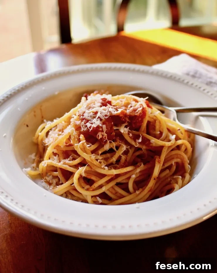 Spaghetti with Bacon Sauce, in bowl with spoon and fork.