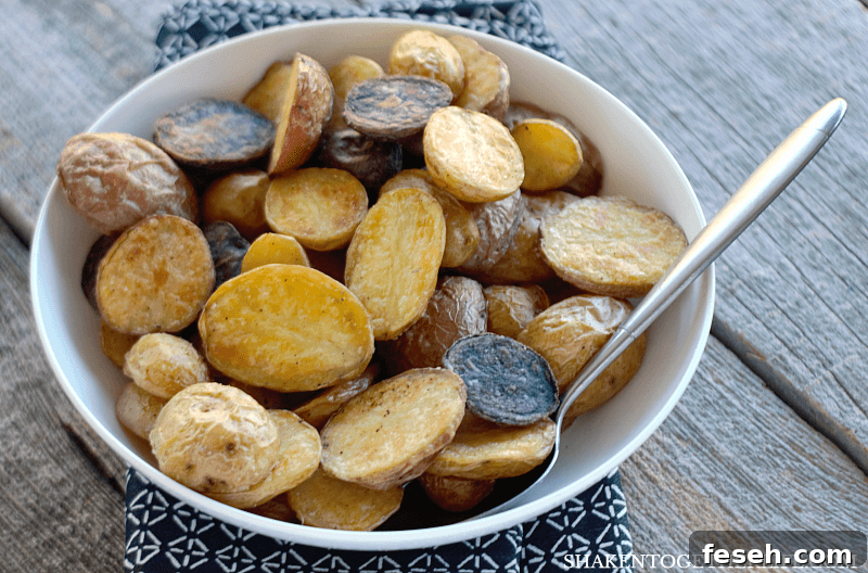crispy Roasted Potatoes in a white bowl with a spoon
