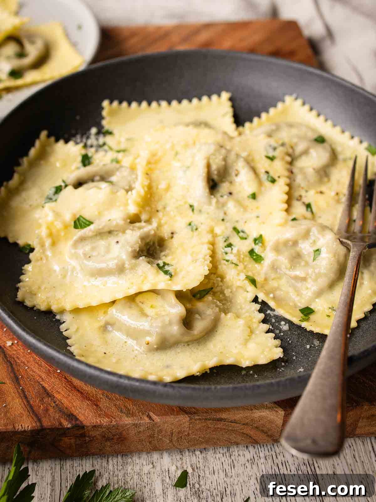 Mushroom Ravioli in a shallow bowl with a sprinkle of chopped parsley.