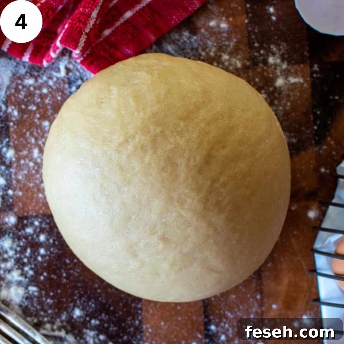 A ball of pasta dough on a wooden board.