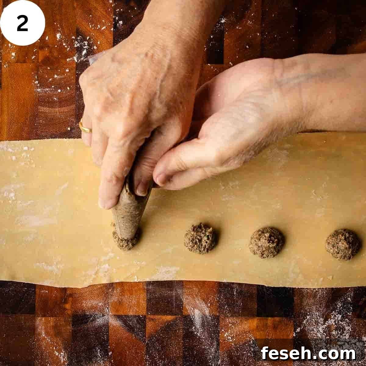 Mushroom filling being piped onto a thinned sheet of pasta dough.