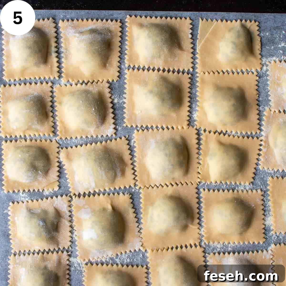 Filled ravioli arrange in one layer on a baking sheet.