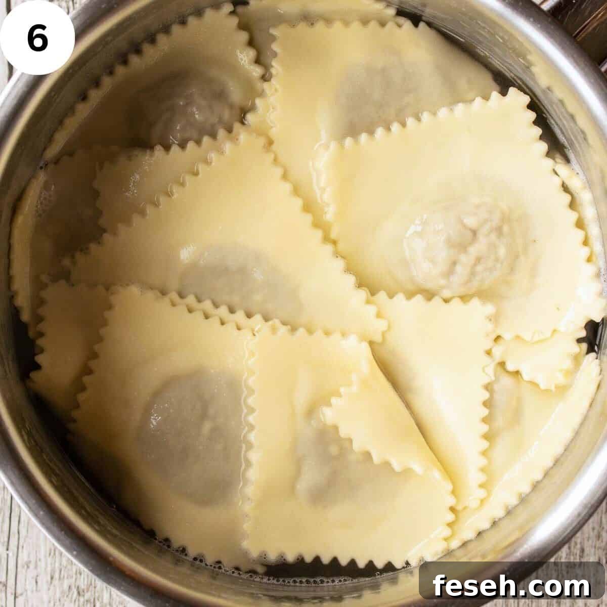 Ravioli in a pot filled with water.