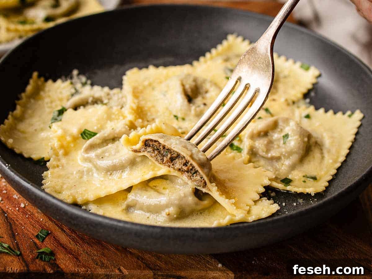 Ravioli filled with mushrooms, cut in half and held on a fork.