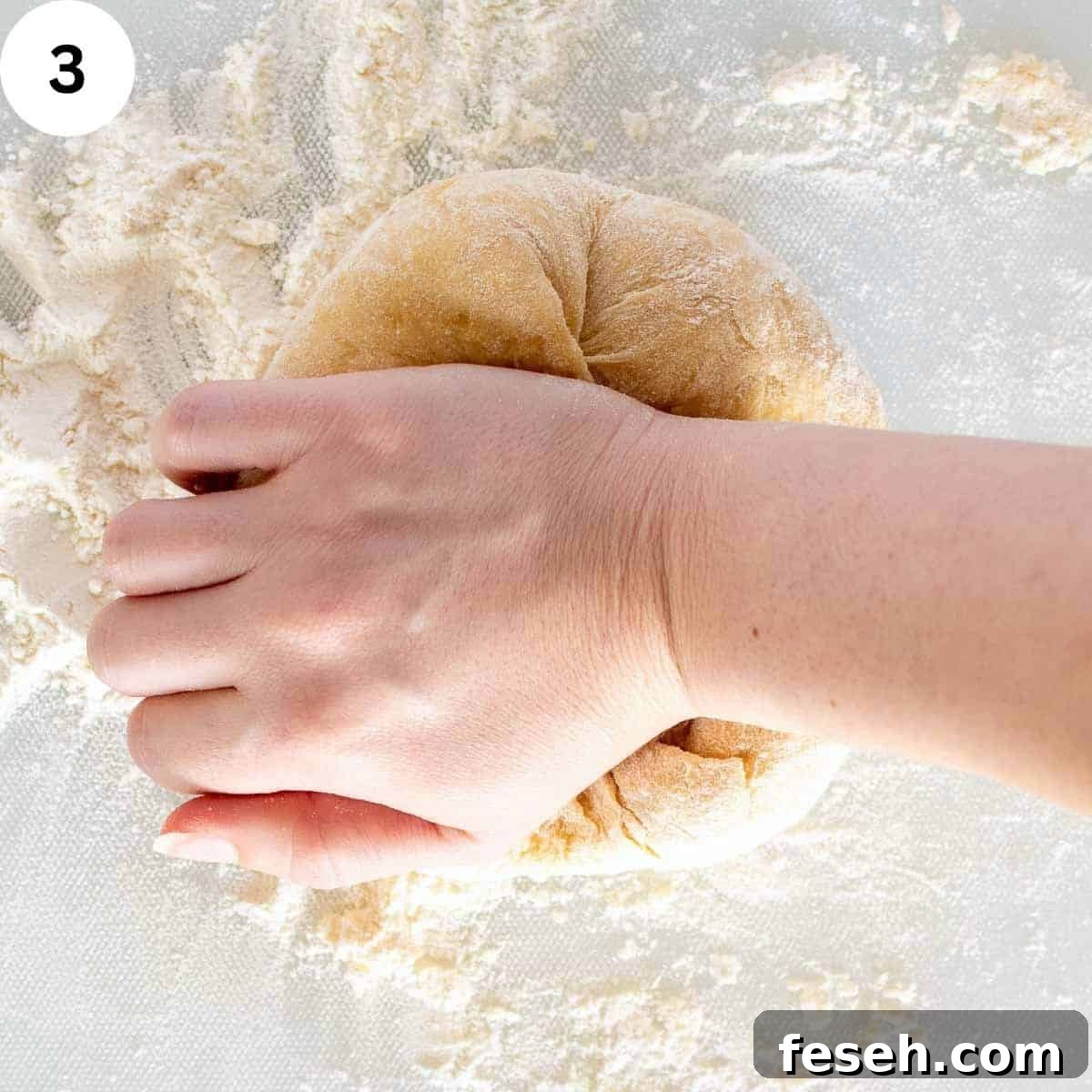 A hand kneading pasta dough.