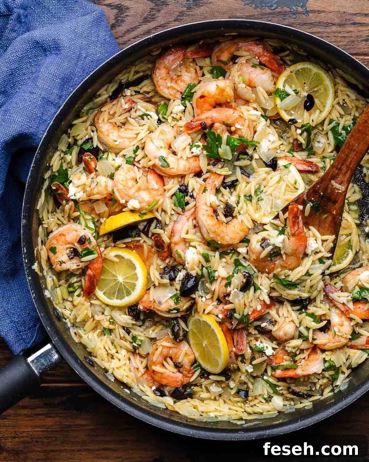 Large pan with orzo and shrimp with feta and black olives.