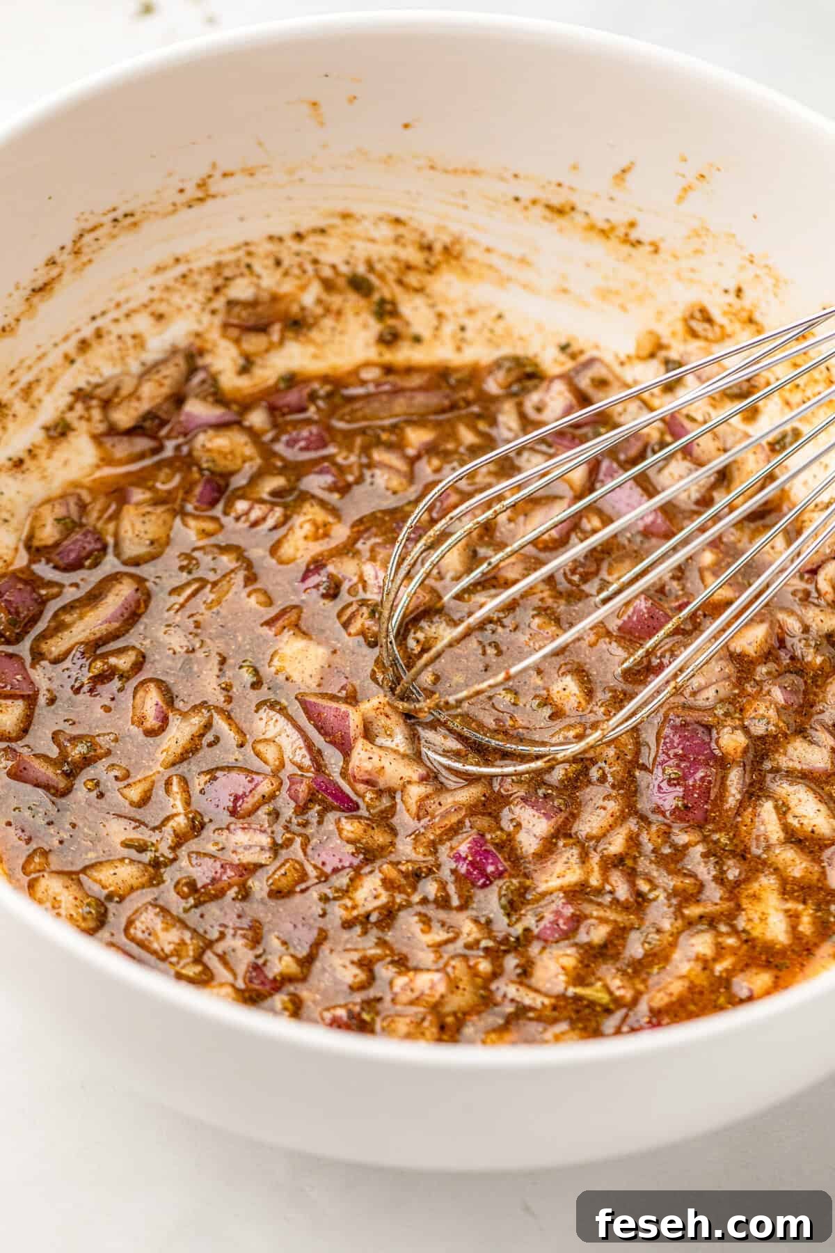 Whisking marinade ingredients in bowl for Pollo Asado recipe