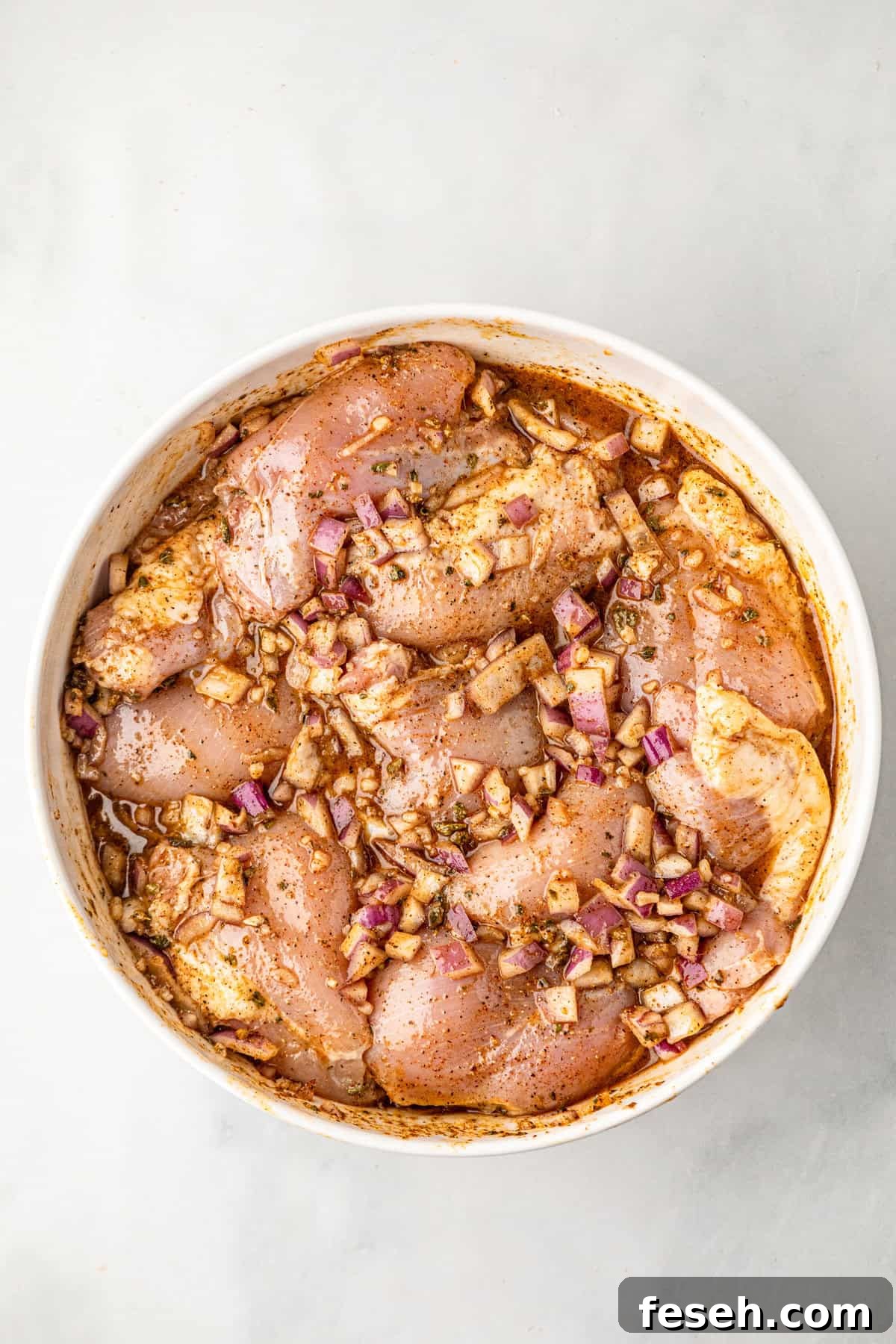 Chicken in marinade bowl for Grilled Pollo Asado recipe