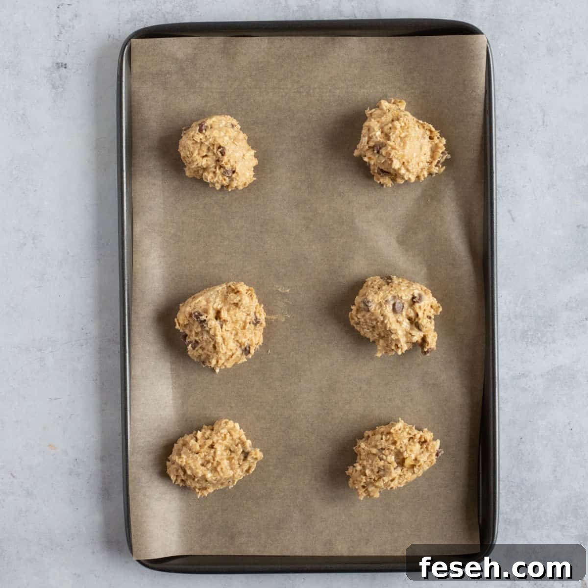 Unbaked banana oat cookies on a baking sheet.