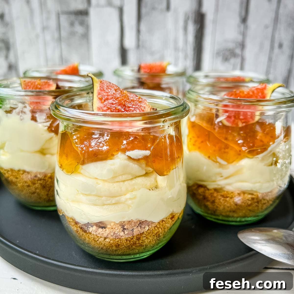 Ready prepared layer dessert. Fig cheesecake without baking with cream cheese filling, cookie base and fig preserve on top.