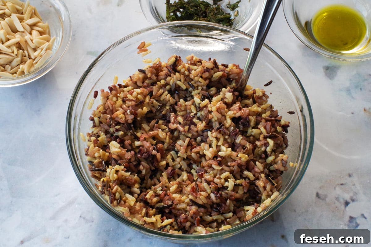 Cooked rice in a glass bowl with spoon.