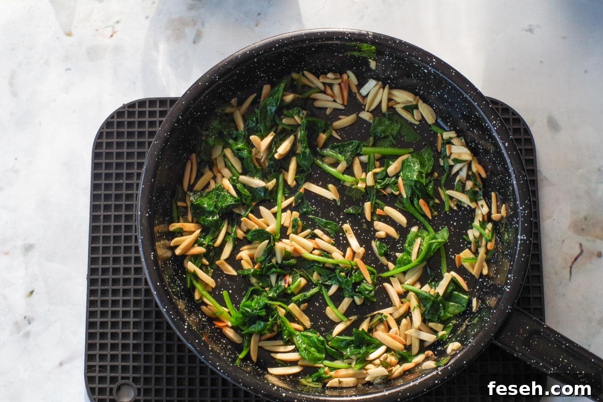 Sage and spinach added to frying pan with nuts.