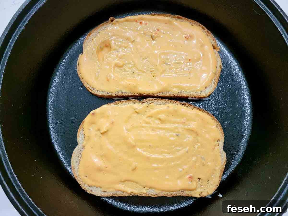 thousand island dressing on two slices of rye bread in a cast iron skillet.