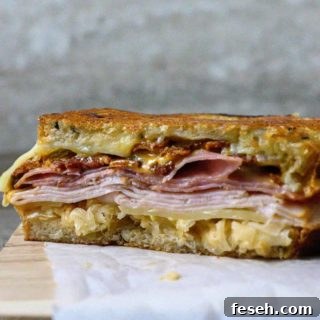 Reuben Club Sandwich cut open on parchment paper.