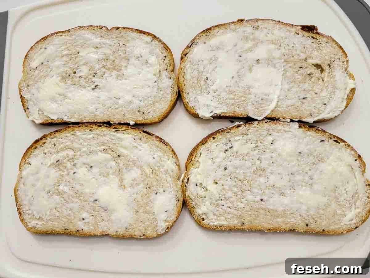 4 slices of rye bread spread with butter.