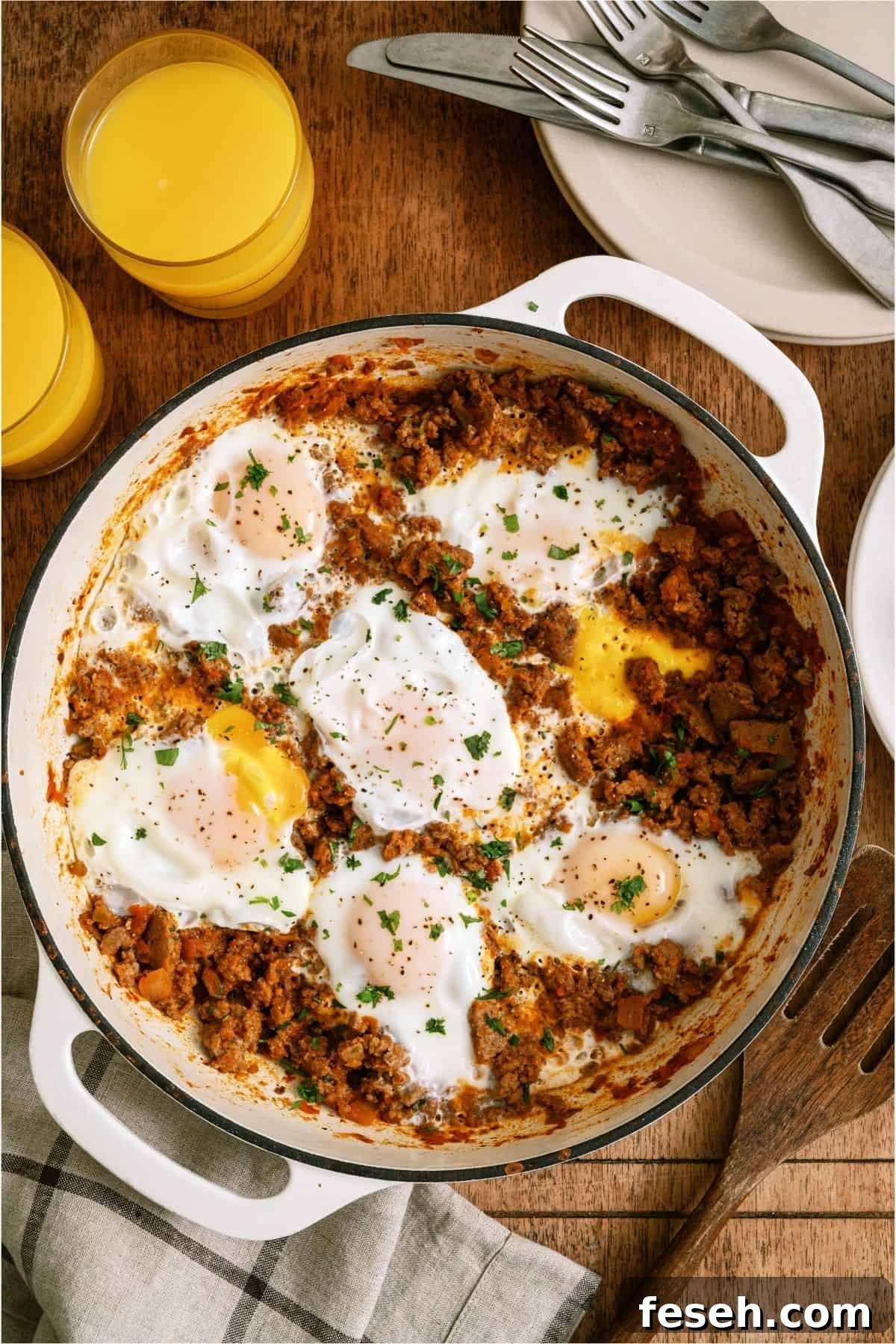 Top view of One Pan Egg and Turkey Skillet in the skillet with two glasses of orange juice on the side.