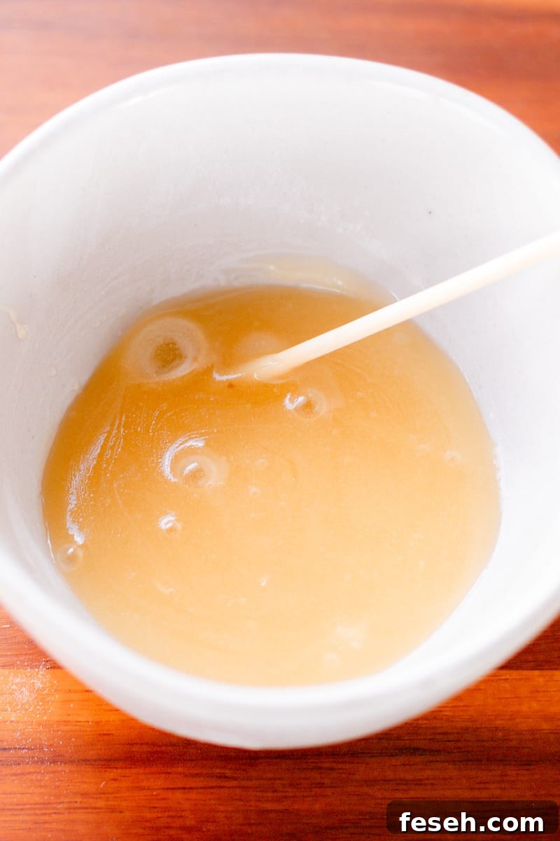A homemade face mask using baking soda in a small white bowl.