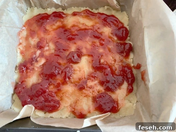 The strawberry jam spread on the crust.
