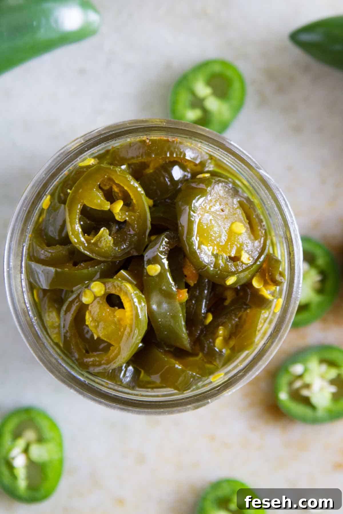 Top down view of a jar of candied jalapeños.