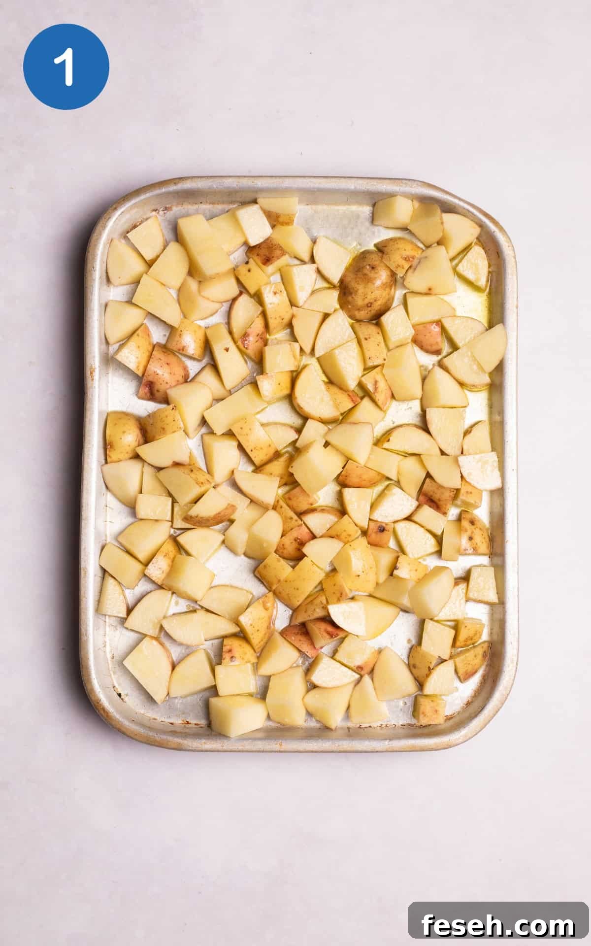 potatoes coated with olive oil in a pan.