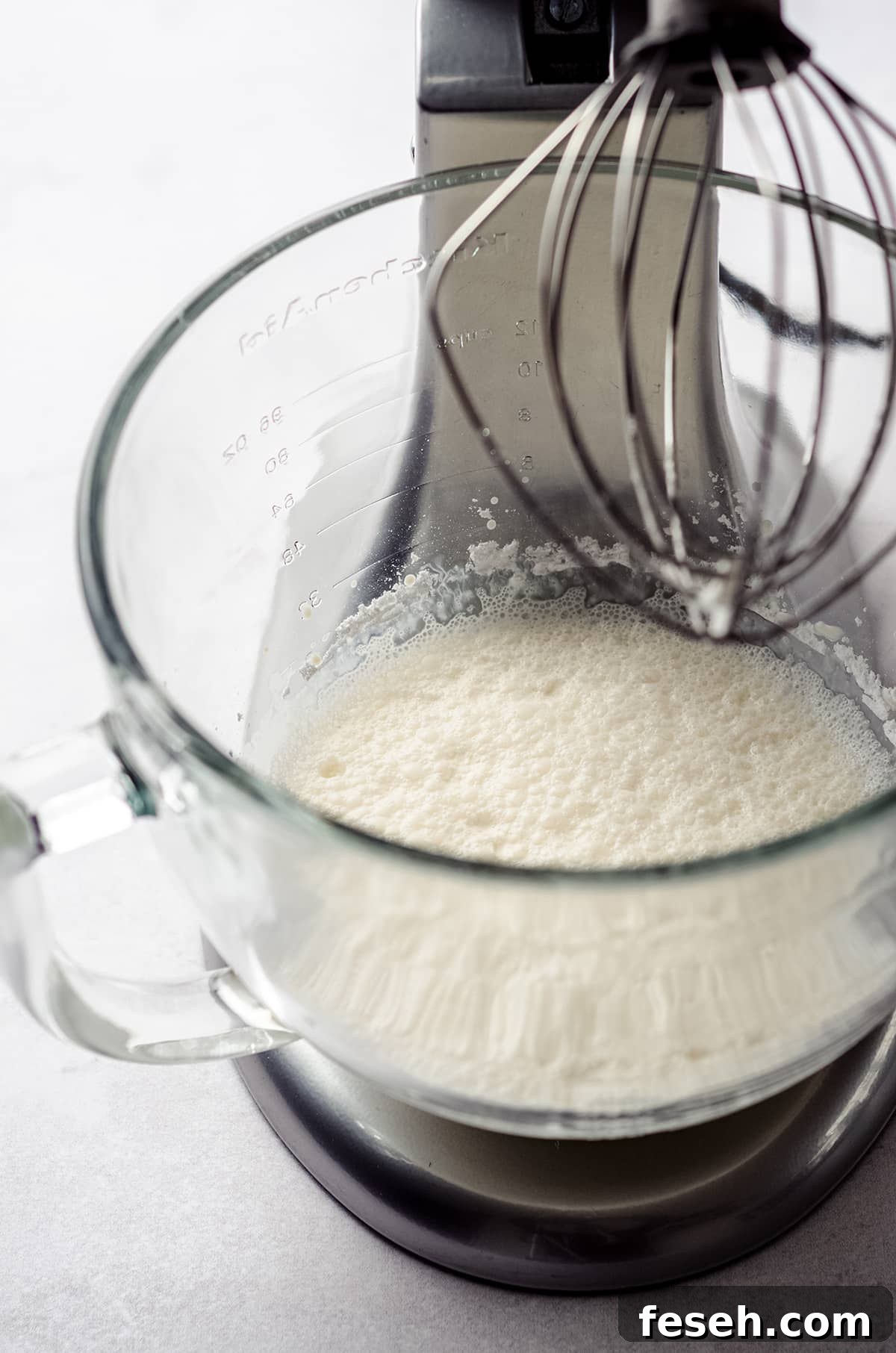 process photo of making pumpkin spiced whipped cream while it is in the bowl of a stand mixer