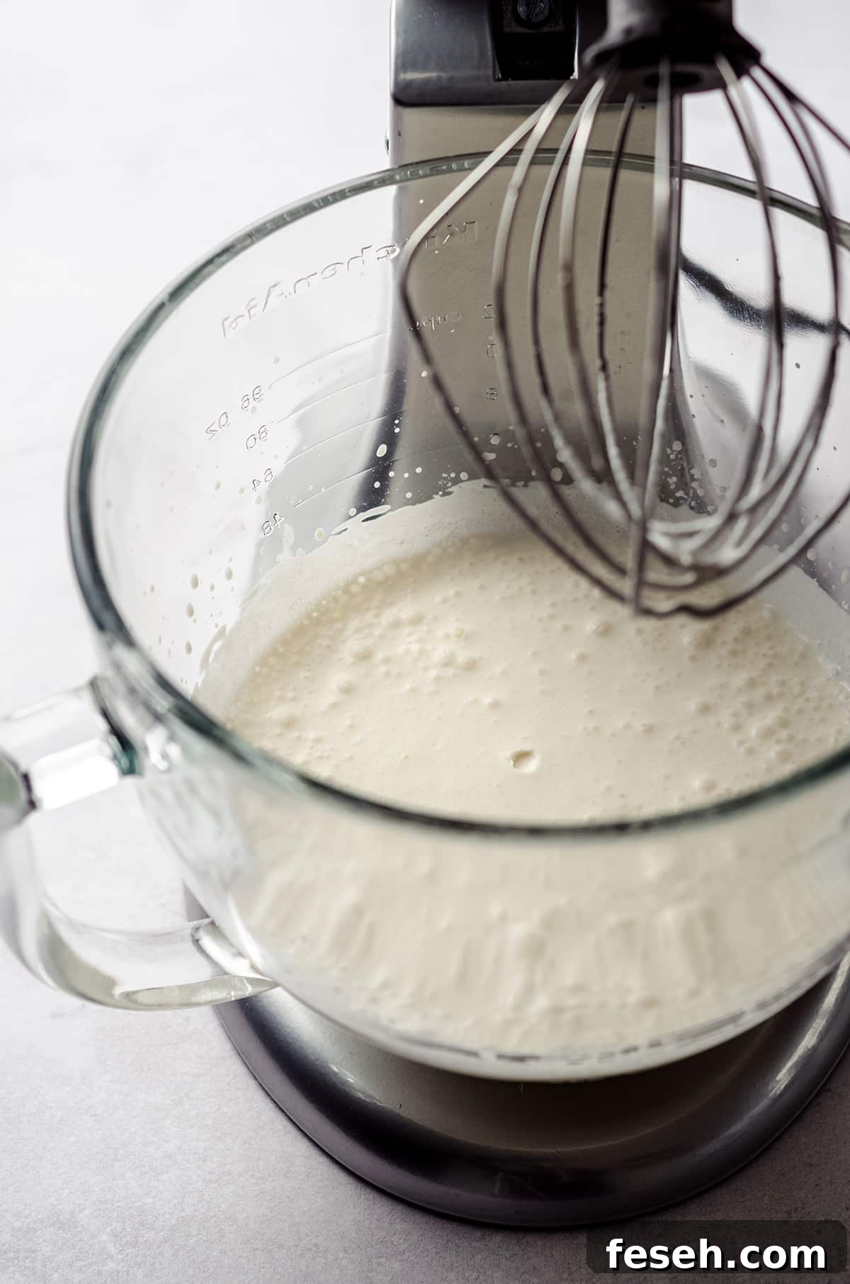 process photo of making pumpkin spiced whipped cream while it is in the bowl of a stand mixer
