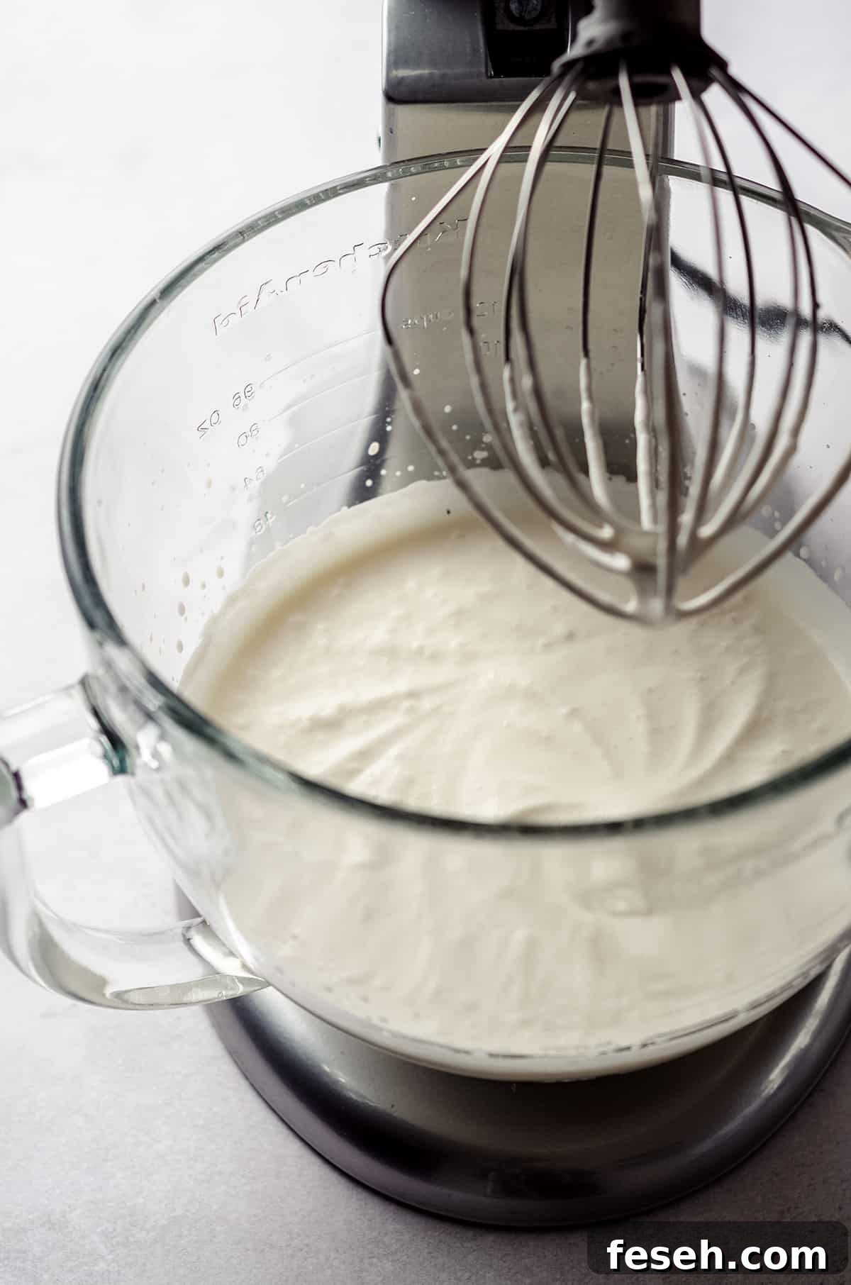 process photo of making pumpkin spiced whipped cream while it is in the bowl of a stand mixer