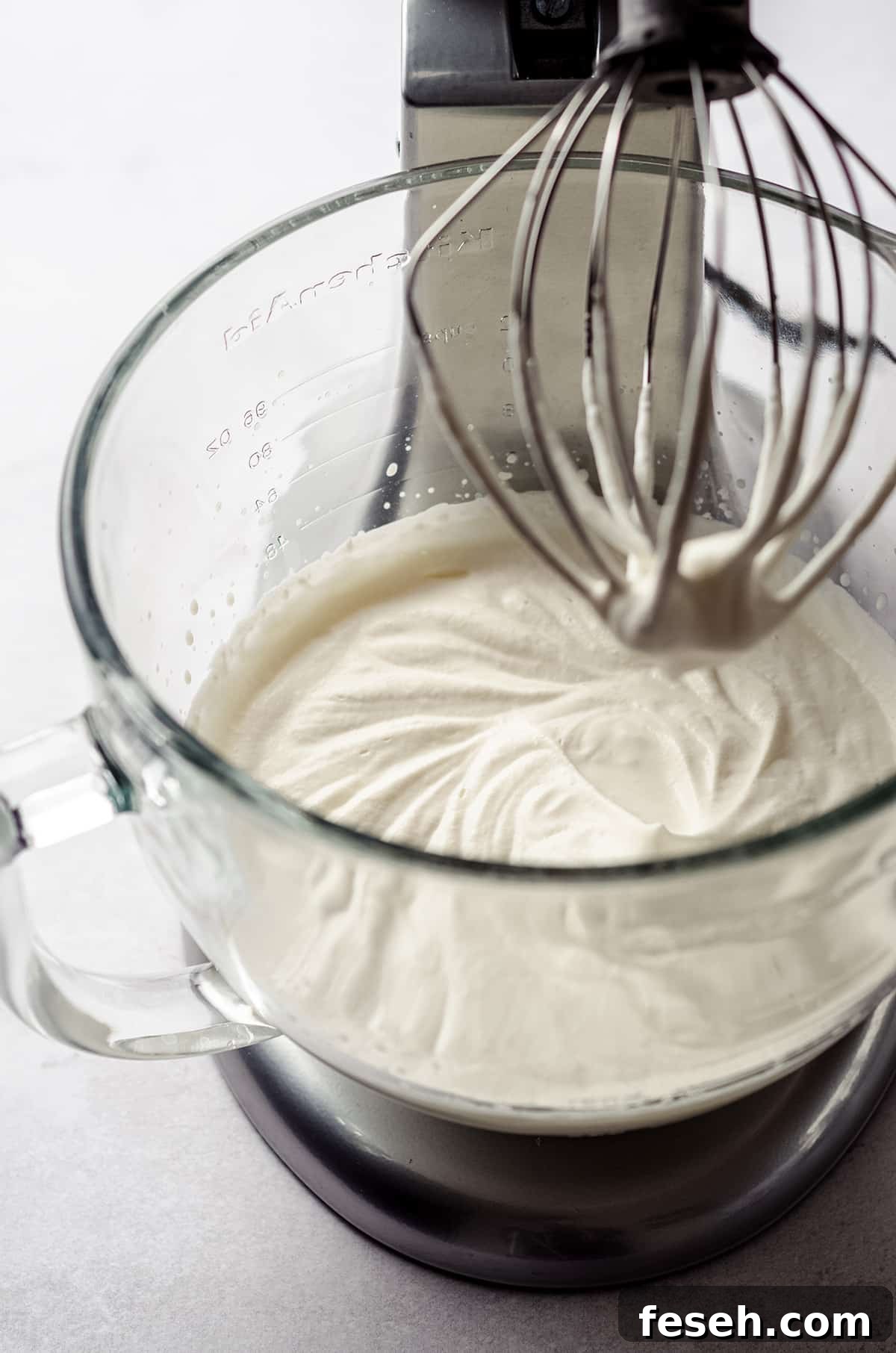 process photo of making pumpkin spiced whipped cream while it is in the bowl of a stand mixer